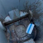 Inside of a dirty gray trash can caked with grime before a Rad Cans cleaning